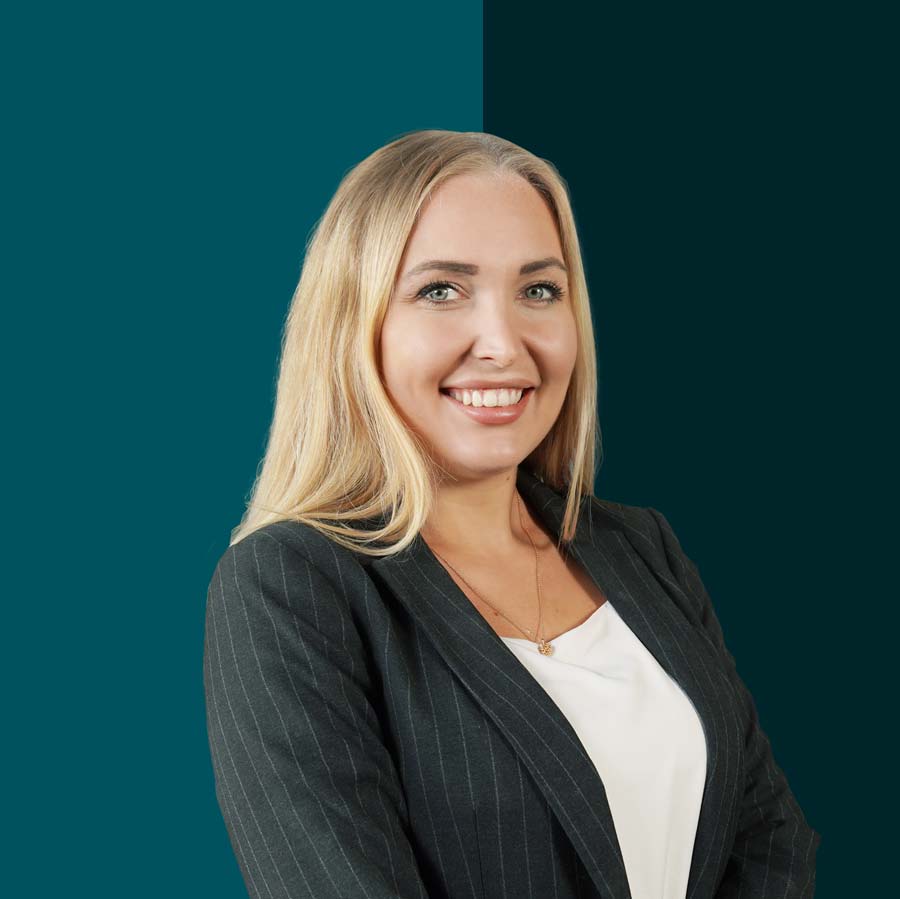 Celina Sever Recruiterin bei ZaberSolar mit den Photovoltaik Jobs. Sie steht vor einem dunklem Hintergrund, leicht nach recht eingedreht im schwarzen Blazer und weißem Shirt. Blondes langes Haar und ein Zähne zeigendes Lächeln.